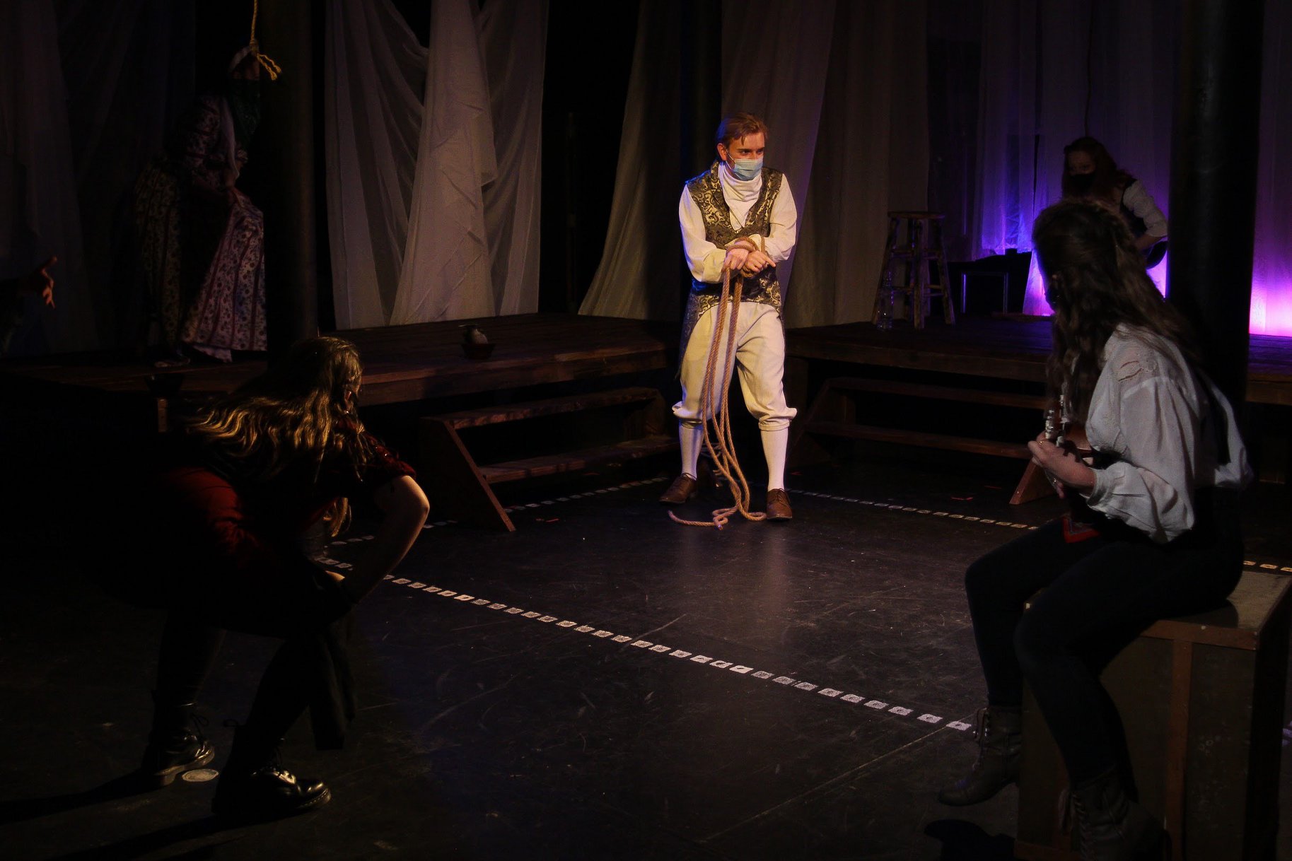 A group of people dressed as pirates with a man standing in center, wearing medical mask